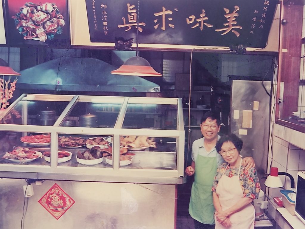 阿霞飯店的五弟吳壽春與二姐吳錦霞於匾額美味求真前的合影